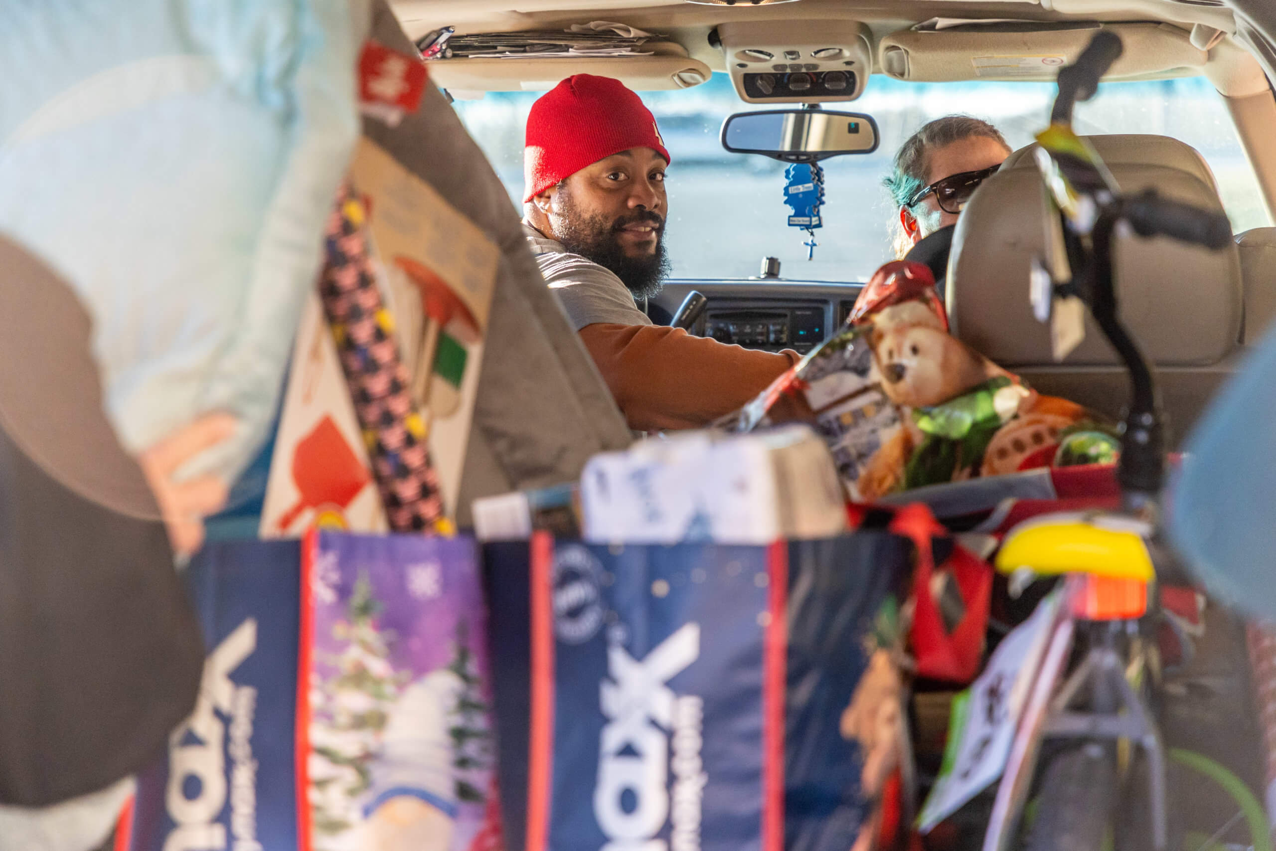Give Joy recipient surrounded by gifts in car