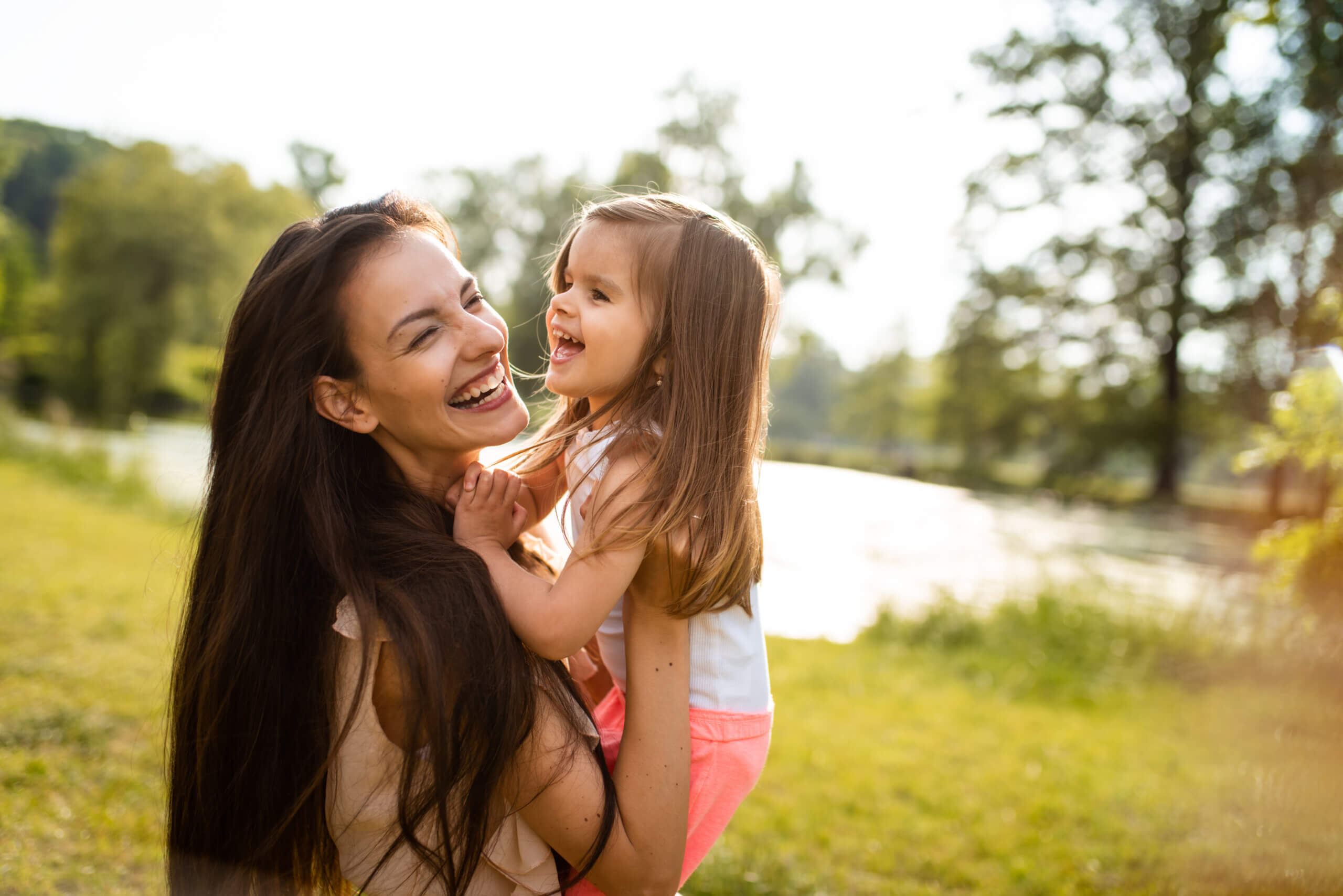 Woman with bright smile holding her daughter
