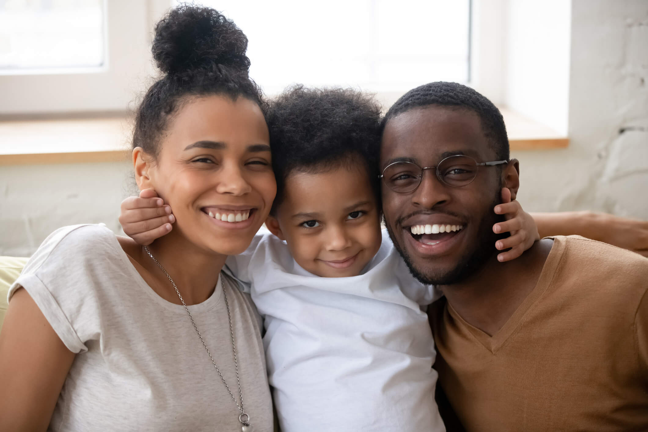 Portrait of happy young family posing with little son